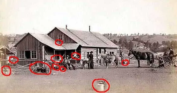 Old frontier homestead with outbuildings, tools and water barrels